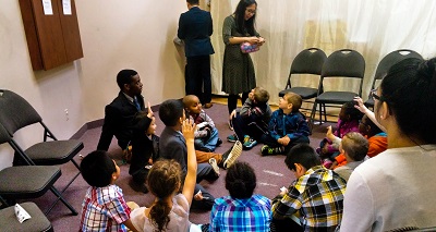a group of children siting in a circle playing a game